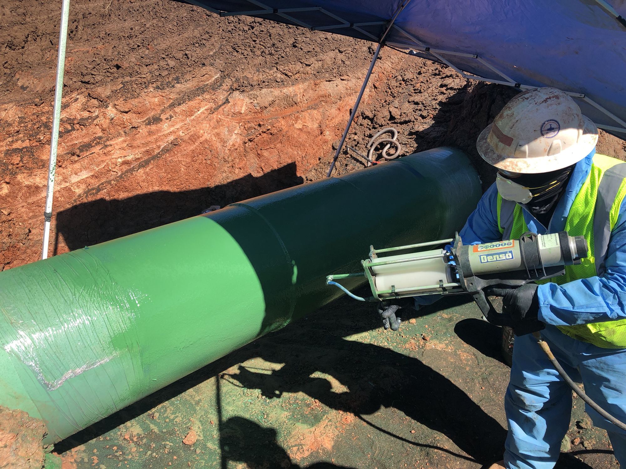 Protective coating application on a pipeline in the field