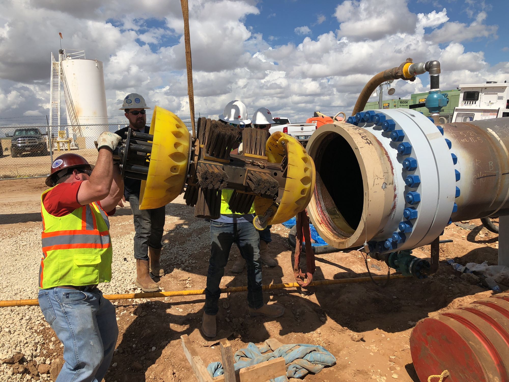 Field crew handling pipeline inspection equipment at a launcher